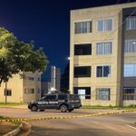 Cena de crime isolada por polícia no Guará II, Distrito Federal, com viaturas e fita de isolamento em rua residencial.