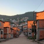 Rua vazia em favela brasileira com marcas de violência, ilustrando estudo sobre risco maior de morte violenta para negros no Brasil.