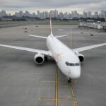 Avião da Gol em aeroporto brasileiro com Cristo Redentor ao fundo, representando legado da companhia aérea.