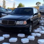 Carro funerário com pacotes de cocaína e viaturas policiais em rua de Luziânia, Goiás.