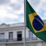 Bandeira brasileira a meio mastro em prédio no Rio de Janeiro, representando luto por brasileiro morto na Guerra da Ucrânia.