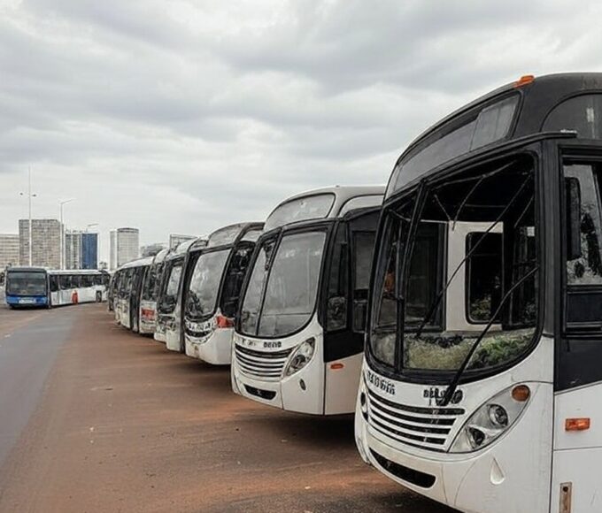 Ônibus depredados por vândalos em rua de Brasília, DF, com danos visíveis em vidros e carrocerias.