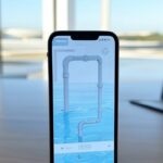 Smartphone com site falso de saneamento em mesa de escritório em Brasília, alertando para golpes online no DF.