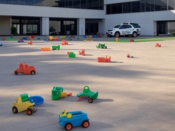 Fachada de creche em Brasília com câmeras de segurança e brinquedos no pátio vazio, representando caso de agressões filmadas.