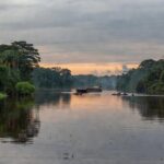 Rio Tapajós na Amazônia, com canoas indígenas e floresta preservada, representando revogação de privatização de hidrovias após protestos.