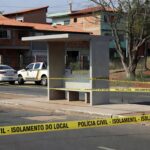 Parada de ônibus em Planaltina isolada por fita policial, com viaturas da Polícia Civil ao fundo, representando cena de crime no Distrito Federal.