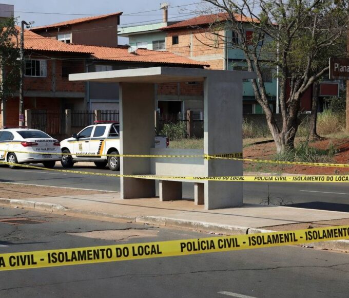 Parada de ônibus em Planaltina isolada por fita policial, com viaturas da Polícia Civil ao fundo, representando cena de crime no Distrito Federal.