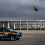 Fachada da CLDF com viaturas policiais, representando impunidade na reintegração de policiais e falhas no combate à violência contra a mulher.