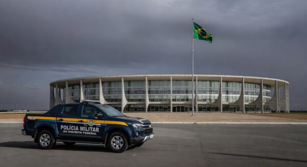 Fachada da CLDF com viaturas policiais, representando impunidade na reintegração de policiais e falhas no combate à violência contra a mulher.