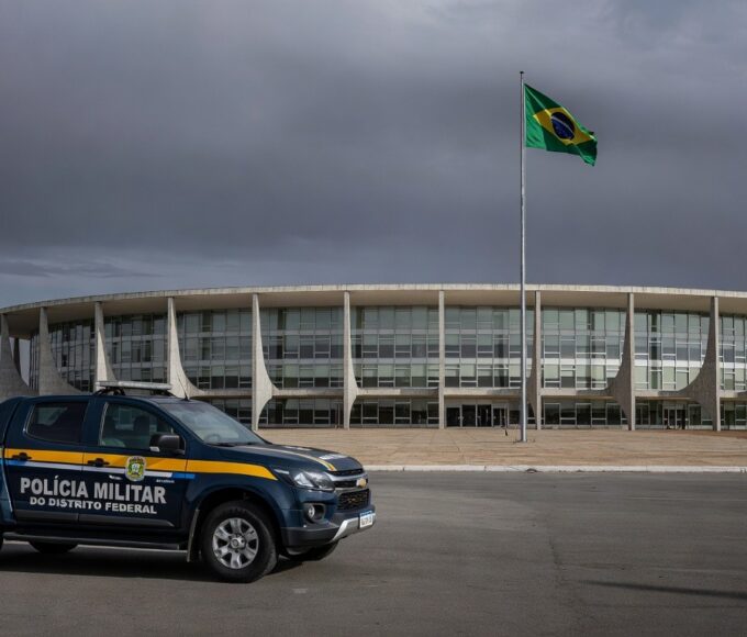 Fachada da CLDF com viaturas policiais, representando impunidade na reintegração de policiais e falhas no combate à violência contra a mulher.