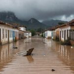 Paisagem de enchentes em cidade de Minas Gerais, com ruas alagadas e casas submersas, simbolizando auxílio para vítimas.
