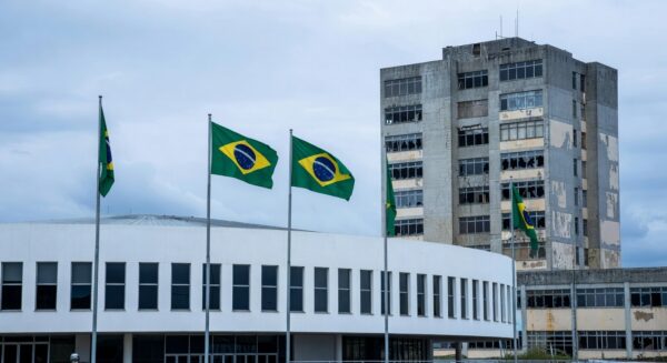 Fachada da CLDF em Brasília com decorações festivas e hospital público deteriorado, destacando falhas no sistema de saúde do DF.
