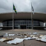 Edifício da CLDF em Brasília com luzes acesas e documentos espalhados, representando desperdício em sessão solene para corretores de seguros.