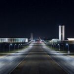 Rua noturna em Brasília iluminada por postes de LED modernos, representando a modernização da iluminação pública no Distrito Federal.