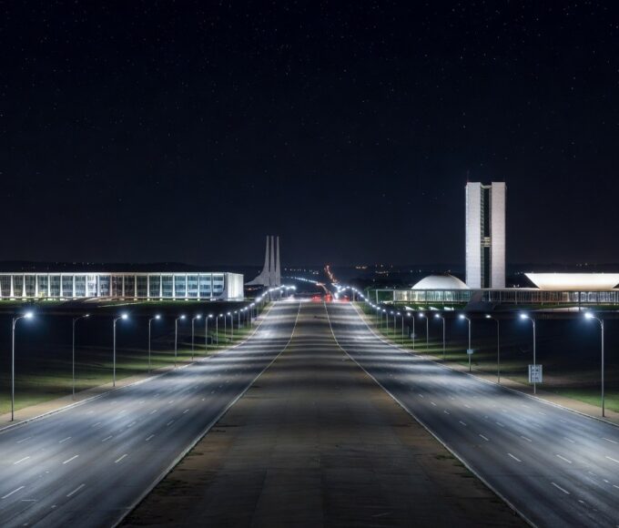 Rua noturna em Brasília iluminada por postes de LED modernos, representando a modernização da iluminação pública no Distrito Federal.