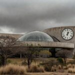 Fachada da Câmara Legislativa do DF sob céu nublado, simbolizando lei contra exclusão de idosos e preconceito persistente.