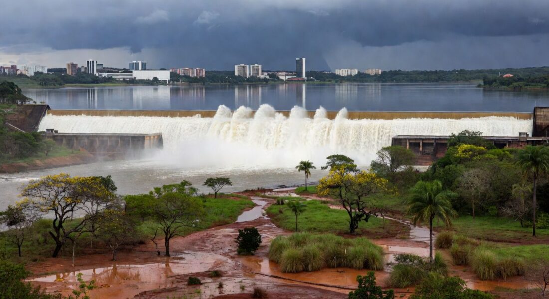 Barragem de Santa Maria transbordando no DF após seca, alertando para riscos de inundações.