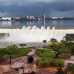 Barragem de Santa Maria transbordando no DF após seca, alertando para riscos de inundações.