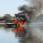 Incêndio em lancha no Lago Paranoá, Brasília, com fumaça subindo da embarcação.
